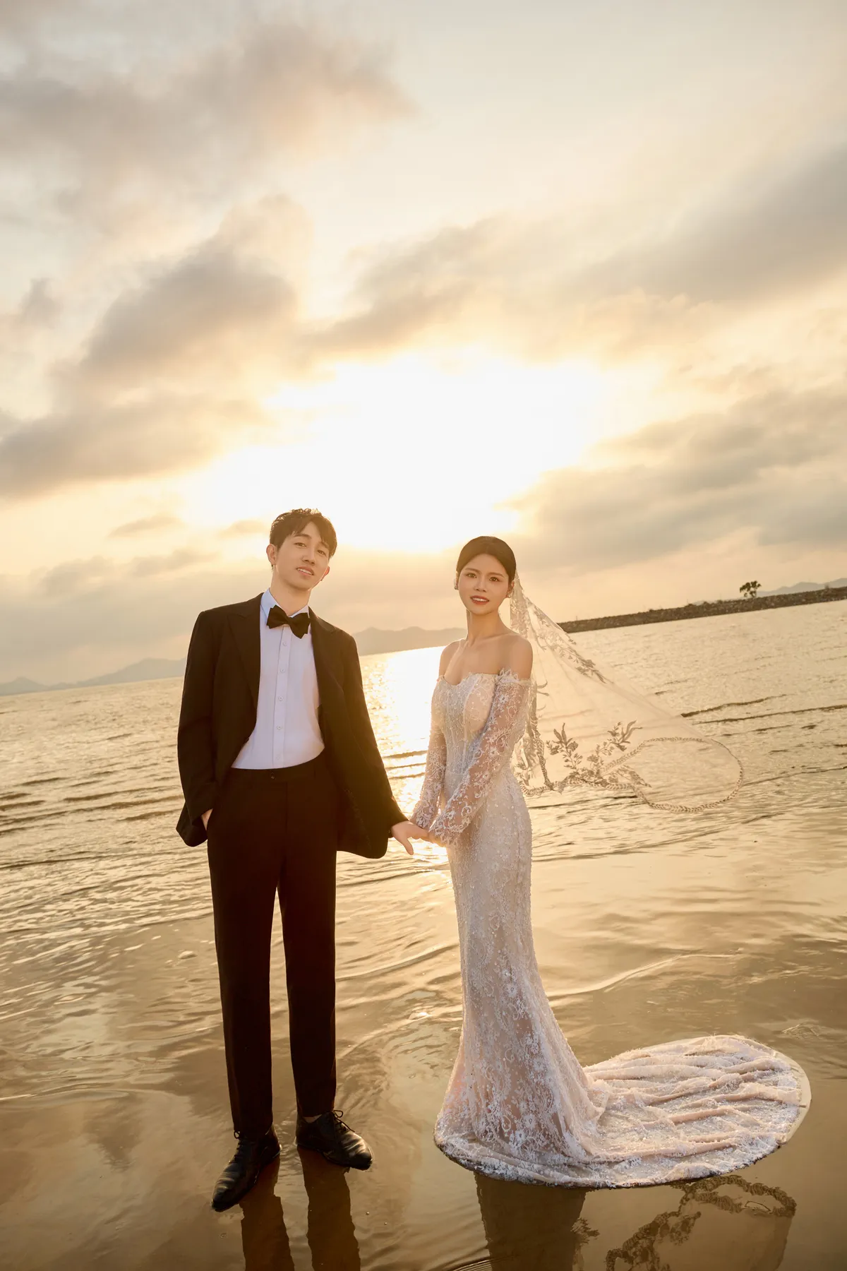 在夕阳海边并肩而立的新郎与新娘